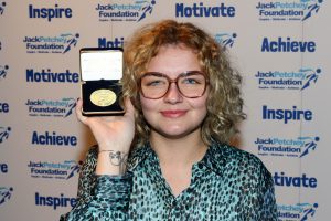 Lily holding her Achievement Award medallion at a Jack Petchey Foundation celebration event