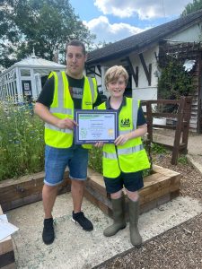 Logan with his award in a garden