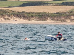 Photo of a man on a raft and Sahishnu swimming the English Channel